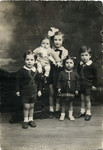 Studio portrait of the five Weisz siblings.

Pictured (left to right) are Georges, Yehudit holding brother Paul,  Esther, and Georges' twin Henri.
