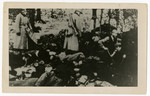 Men with shovels dig pits next to the corpses of those recently executed by German police,

This copy print is one found by Jacob Igra in an apartment in Sosnowiec after the war.