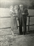A Jewish family in Poland poses next to a wooden fence.
