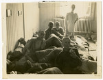 Survivors of the Buchenwald concentration camp recuperate inside a building [perhaps a makeshift hospital] following liberation.