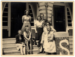 Girls from the graduation class of the Dutch Montessori Lyceum stand on the exterior steps of the school shortly after the German invasion of Holland.