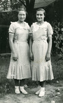 Eva (Hava) Weiss (left) and her cousin, Yolanda Schwaitz (right) pose in matching dresses.