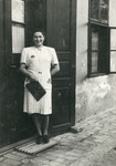 Eva (Hava) Weiss stands in front of the entrance to a building in the late 1930s.