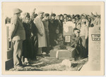 Men and women gather around a grave in a cemetery in Israel.