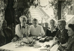 Members of the Duschnitz family sit around a table laden with fruit.