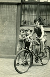 Kurt Hirschhorn rides his bicycle while his younger brother Richard and another young boy look on.
