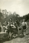 A group of young children play with a wheelbarrow on the grounds of the Chaumont children's home.