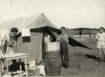 Dario Navarra, Giacomo Muttarazzi, and Moshe Dana work in front of their tent in a detention camp in Cyprus.