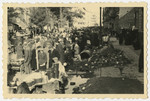Polish men and women crowd into an outdoor market in postwar Warsaw.
