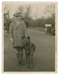 Stanislaw Aronson poses on a street with his dog,