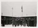 Jewish displaced persons in Munich attend a rally in the snow in an open courtyard with both American and Israeli flags flying.