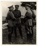 Adolf Hitler confers with his generals.

Pictured (left to right) are Werner von Fritsch, Werner von Blomberg, and Hitler.