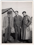 Three German-Jewish refugees stand in front of a barracks in the Kitchener camp.