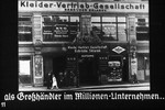 11th Nazi propaganda slide of a Hitler Youth educational presentation entitled "Germany Overcomes Jewry."

als Großhändler im Millionen-Unternehmen..