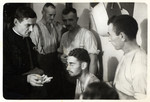 A Polish priest offers cigarettes to German POWs.