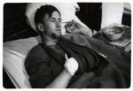 A wounded German POW rests in a hospital bed.
