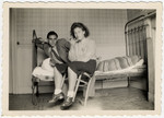 Two Jewish young people pose in a room with a bed and chair.