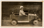 Portrait of Sonia Pressman driving a toy car, in Germany, early 1930s.