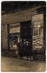 A brother and sister pose in front of their father's cigar store.