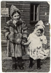 Two Jewish children wearing fur coats and hats, possibly in the Foehrenwald displaced persons camp.