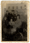Group portrait of six young people, many wearing Jewish badges, in the Lodz ghetto.