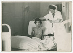 A nurse cares for an emaciated female survivor of the Bergen-Belsen concentration camp.