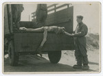 Soldiers load corpses onto trucks prior to the their burial.