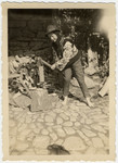 A young woman chops wood with an axe during a class trip to Tresenwald.