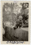 Two-year-old Leslie Rosenthal climbs on a ledge outside the Barbizon children's home near Paris.