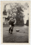 Leslie Rosenthal runs outside the Barbizon children's home wearing rubber boots sent to him from Canada.