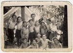 Group portrait of children from the Chateau des Morelles next to a tent in the woods.