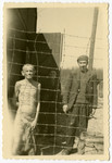 Survivors stand behind a barbed wire fence in Buchenwald.
