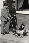 Felix Tikotin pushes his daughter Leentje in a baby carriage down a street in The Hague either right before or right after the German invasion of The Netherlands.