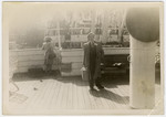 Henry Kolber stands on the deck of a ship holding his suitcase while en route to America.