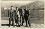 Four youth pose together on the shore of Lake Geneva.