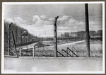 View of a section of the barbed wire fence and row of watch towers that surround the Buchenwald concentration camp.