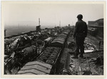 An American soldier inspects rail cars filled with wrecked V-2s which were brought from the underground factory to nearby Kleinbodugen.