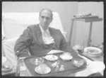 Clandestine photographs of Rudolf Hess sitting in his hospital bed with his tray of food in the Spandau Prison.