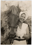 Greta Stoessler Engel stands next to her horse in prewar Austria.