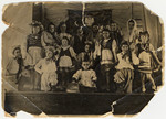 Group portrait of children, many of whom are Jewish refugees, performing on stage in traditional Polish folk costumes.