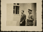 Charles Lindbergh, accompanied by a Nazi officer, walks past a building during the Berlin Olympics.