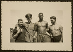 A German in an Army uniform poses with Olympic athletes.