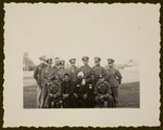 A group of uniformed German soldiers, possibly at the Olympic village, pose with three Indian Olympic athletes.