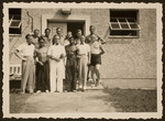 A group of athletes pose in front of one of the residences in the Olympic village.