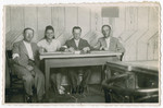 Members of the Jewish Council in Chmielnik seated at a table.