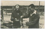 Two survivors of either Ohrdruf or Buchenwald concentration camp prepare a light meal after liberation.