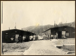 Prisoners and German camp personnel pose before barracks at a POW camp in Montmédy, France during World War I.