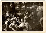 Children and teenagers (many wearing Zionist youth group uniforms) pose during an outing to the woods.
