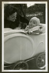 Helga admiries her baby son Romano who sits in his carriage.