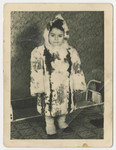 Ellen Zinger stands either in the Bergen-Belsen displaced persons camp while wearing a fur coat and hat.